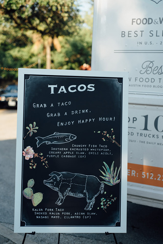 Taco food truck menu with fish and pork options displayed outdoors