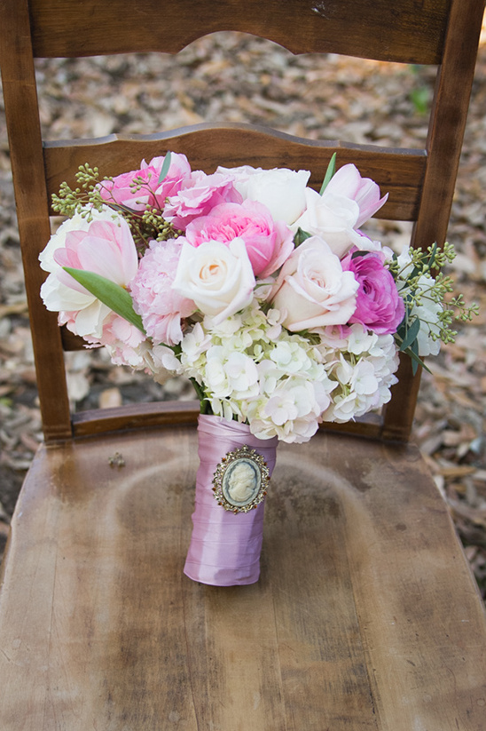 Elegant bridal bouquet of pink roses and hydrangeas on wooden chair