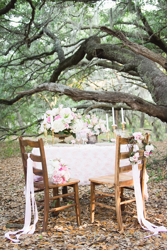 Romantic outdoor wedding setup with flowers and wooden chairs