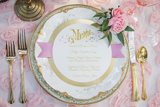 Elegant table setting with menu and pink floral decor