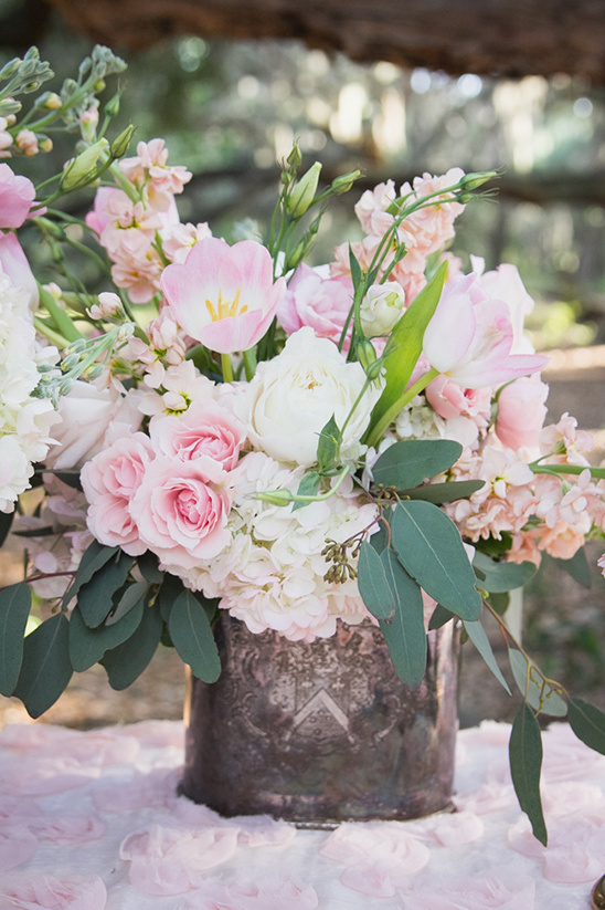 A beautiful bouquet of pink and white flowers in a rustic silver vase