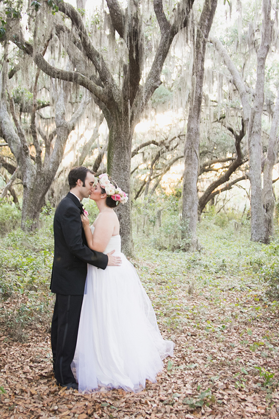 Couple sharing a kiss in a beautiful forest wedding setting