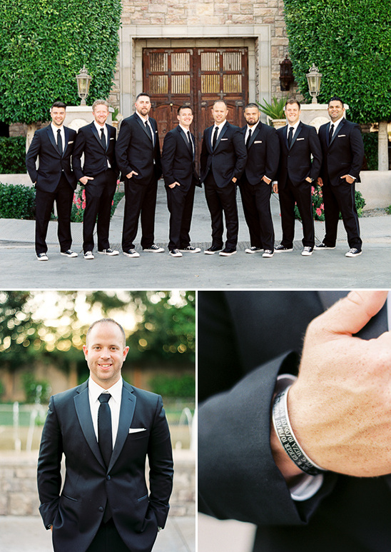 Groom and groomsmen pose in formal black suits with smiles