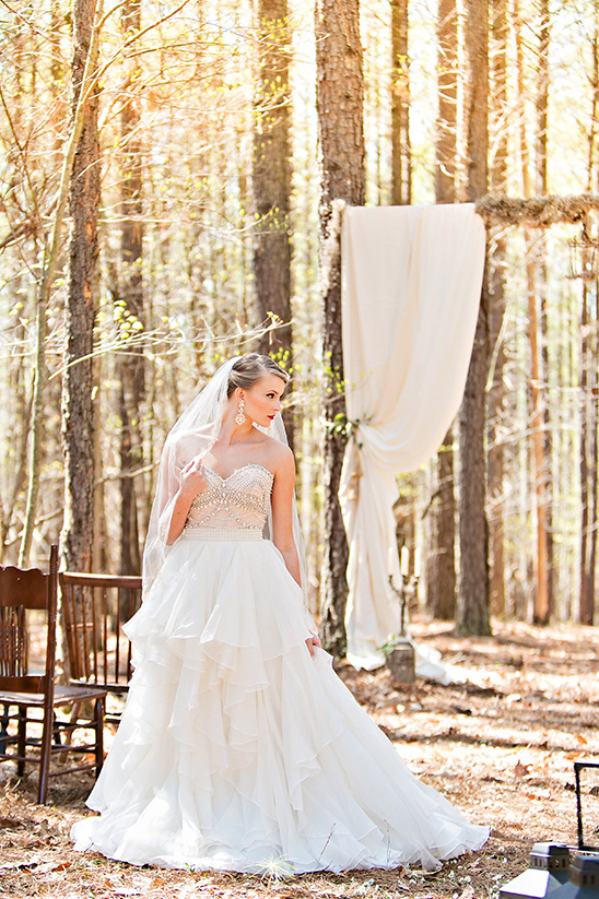 Bride in a forest with a white wedding dress and veil