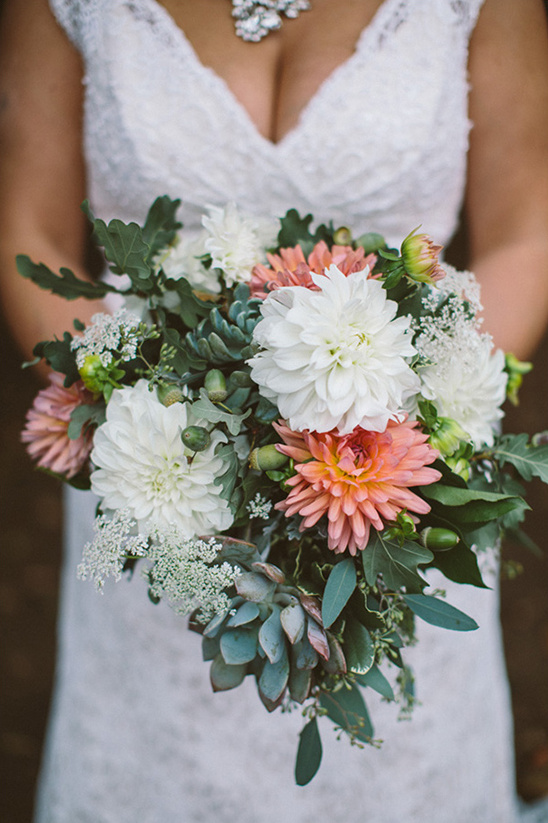 Bride holding a beautiful wedding bouquet with white and coral flowers