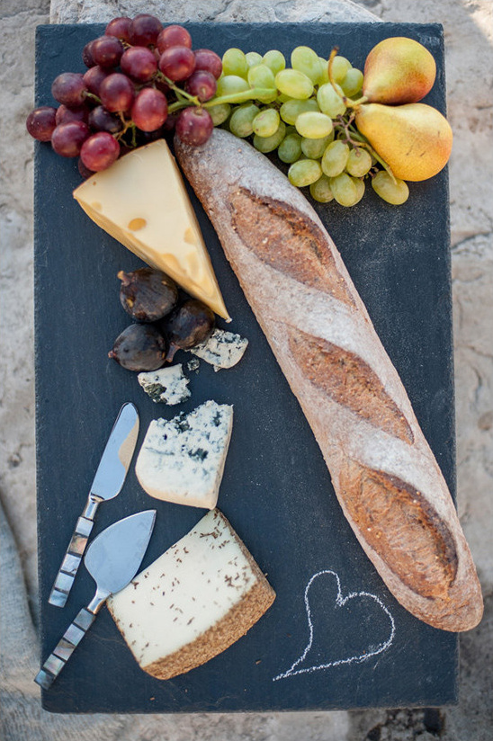Rustic cheese board with baguette fresh fruit and figs