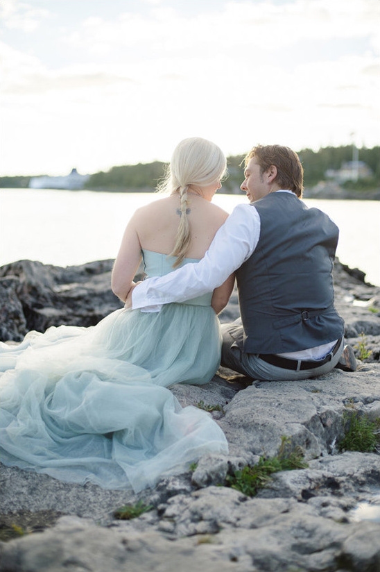 Romantic couple embracing on rocks near the water