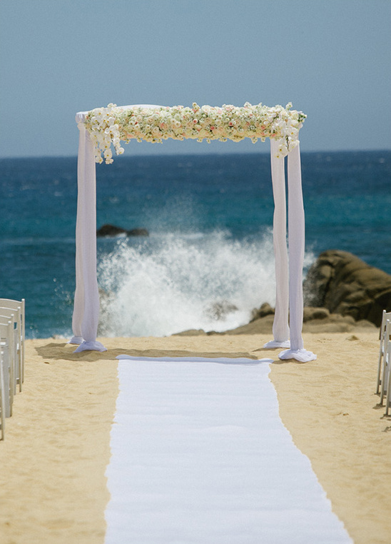 rose wedding arch on beach @weddingchicks