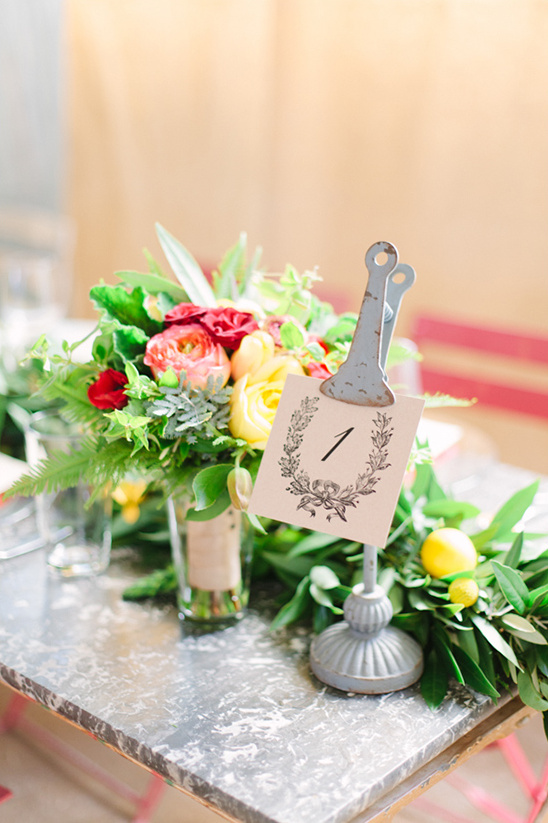 Wedding table decor flowers and rustic number sign