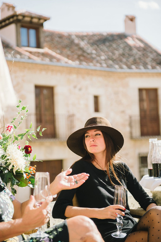 Woman in hat with glass of wine enjoying a sunny day