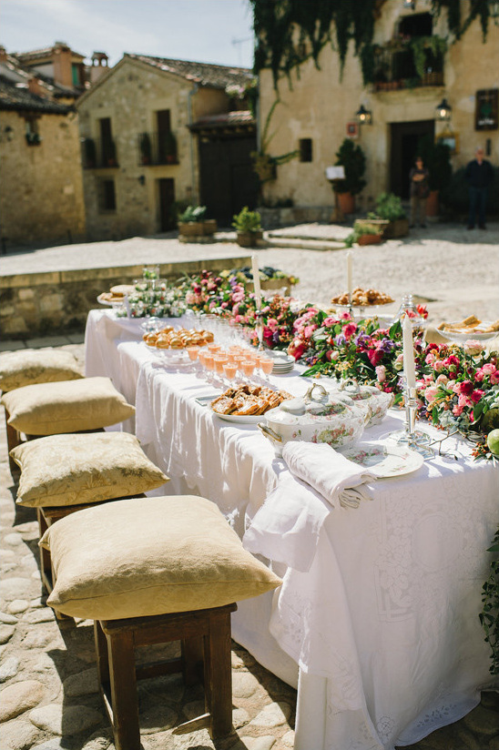 Outdoor wedding reception table decorated with flowers and food