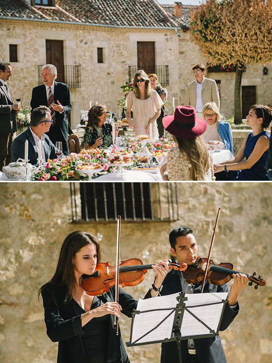 Wedding celebration with guests at long table and violinists