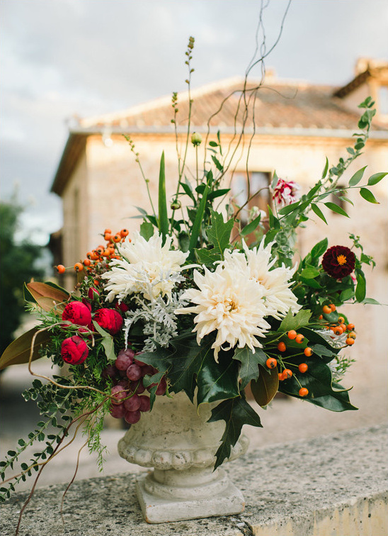 Elegant floral arrangement in a stone vase with building background