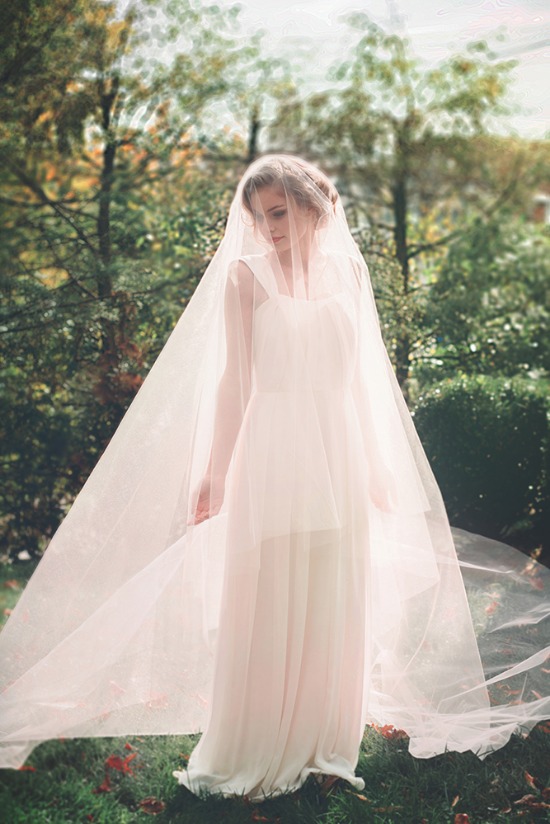 Bride in white dress and veil in garden setting