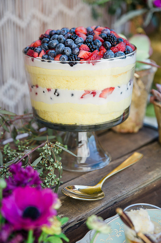 Delicious layered berry trifle dessert ready to be served with a spoon