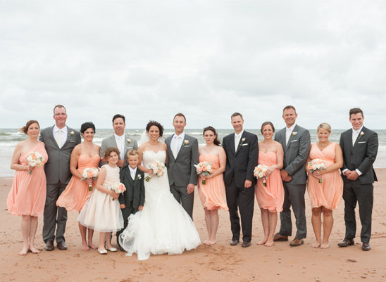 Wedding party posing on a beach with the bride and groom