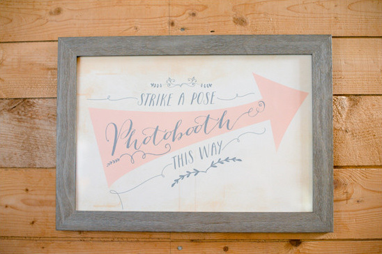 Elegant photobooth sign with a pink arrow and calligraphic text