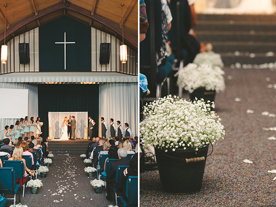 Wedding ceremony with aisle flowers, cross, and happy couple
