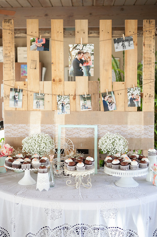 Rustic wedding reception with photos and cupcakes on display