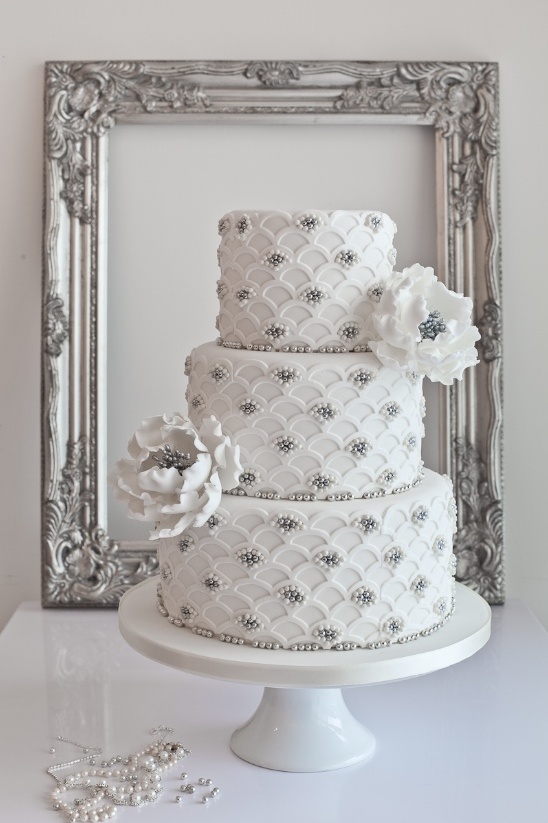 Elegant white wedding cake with floral details and frame