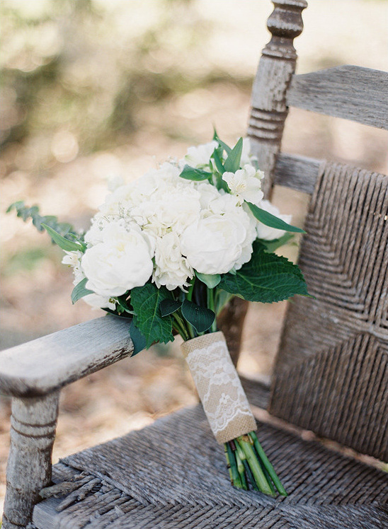 Elegant white wedding bouquet on rustic wooden chair