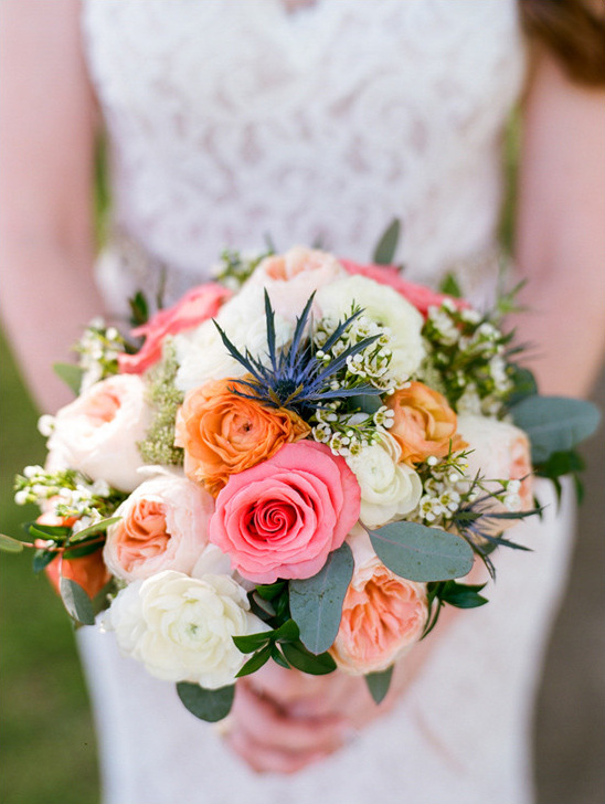 Bride holding a pink and orange rose wedding bouquet