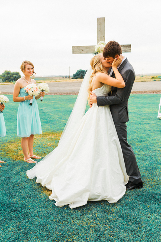 Newlyweds share their first kiss at outdoor wedding