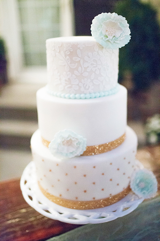 Elegant three tier white wedding cake with gold accents