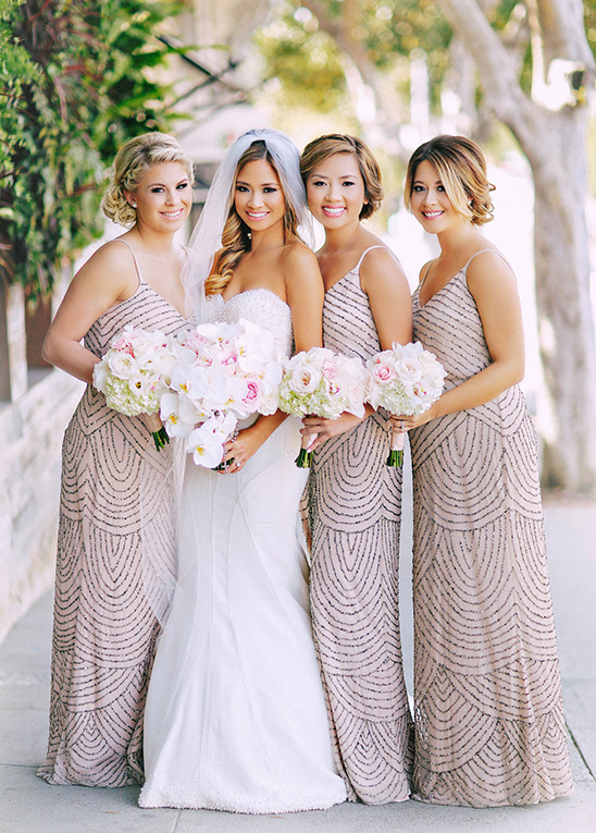 Bride and bridesmaids in beaded gowns with bouquets