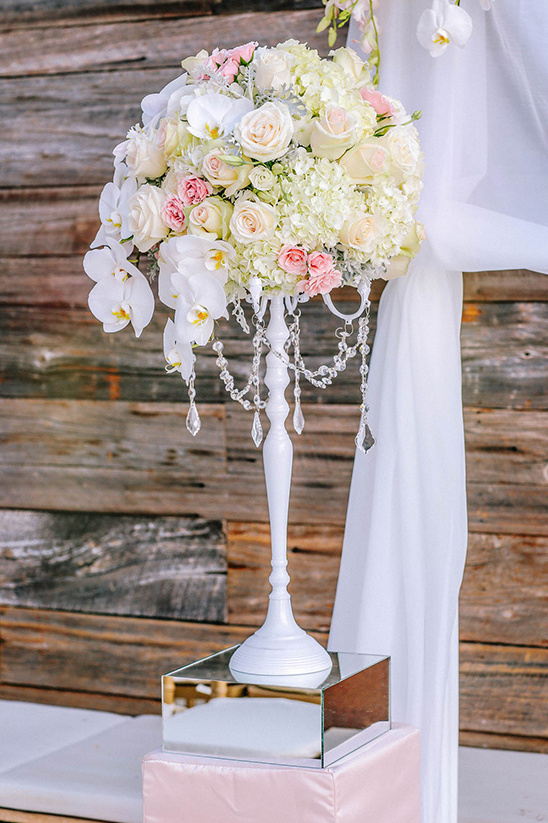 Floral centerpiece with roses and orchids on white stand