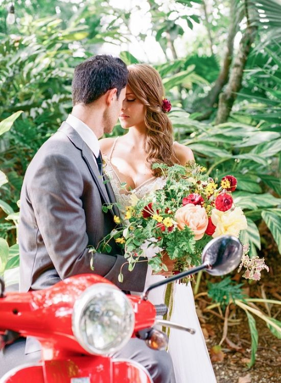 Bride and groom on red scooter romantic wedding day