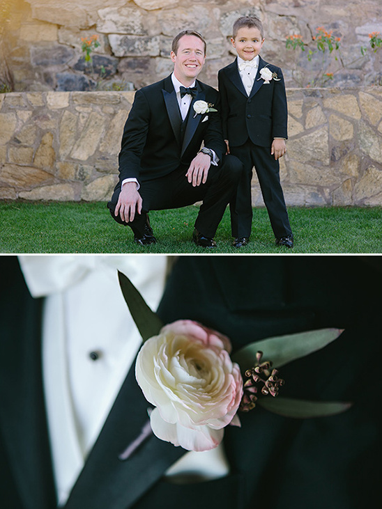 Father and son in tuxedos with a boutonniere detail