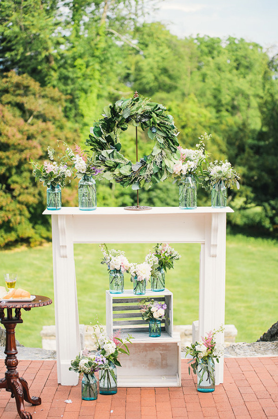 Elegant wedding flowers in mason jars on mantle display