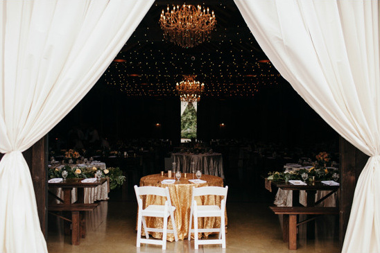 Elegant wedding reception with chandeliers and white curtains