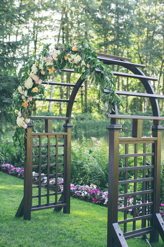 flower covered wedding arch @weddingchicks
