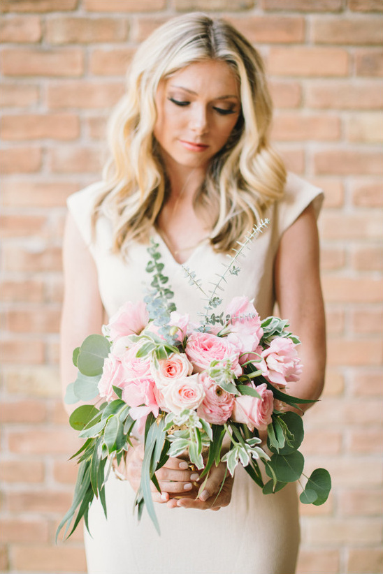 Bride with blonde hair holding a pink rose bouquet