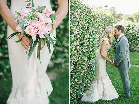 Bride holding pink bouquet kissing groom in garden