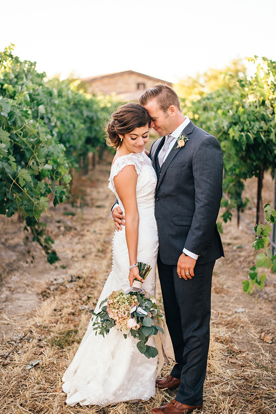 Bride and groom embrace in a beautiful vineyard setting