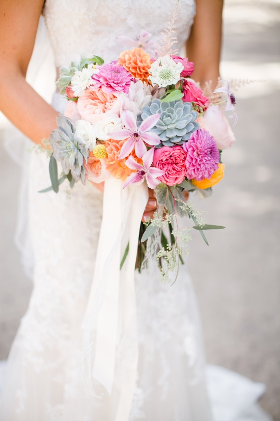 Bride holds colorful wedding bouquet with succulents