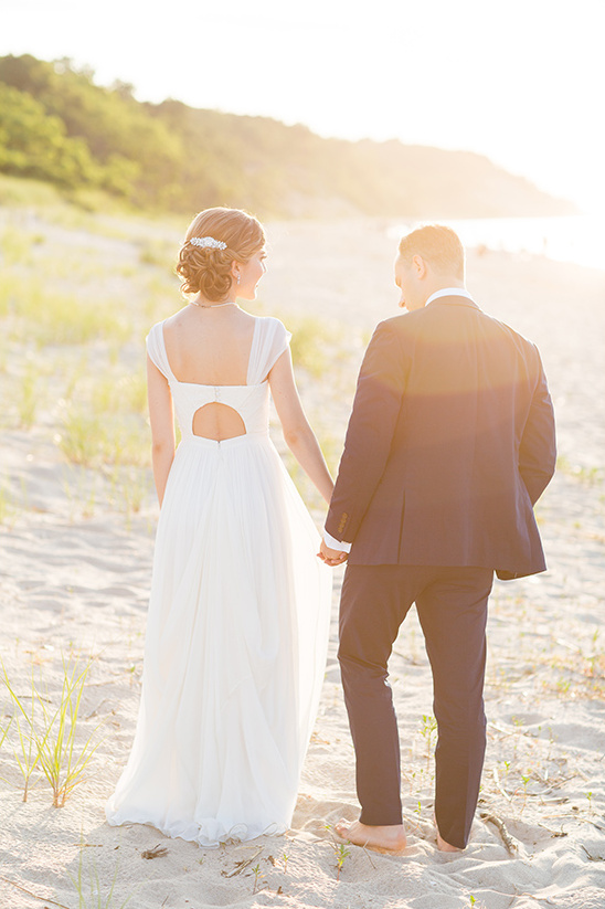 Bride and groom walking on a beach at sunset