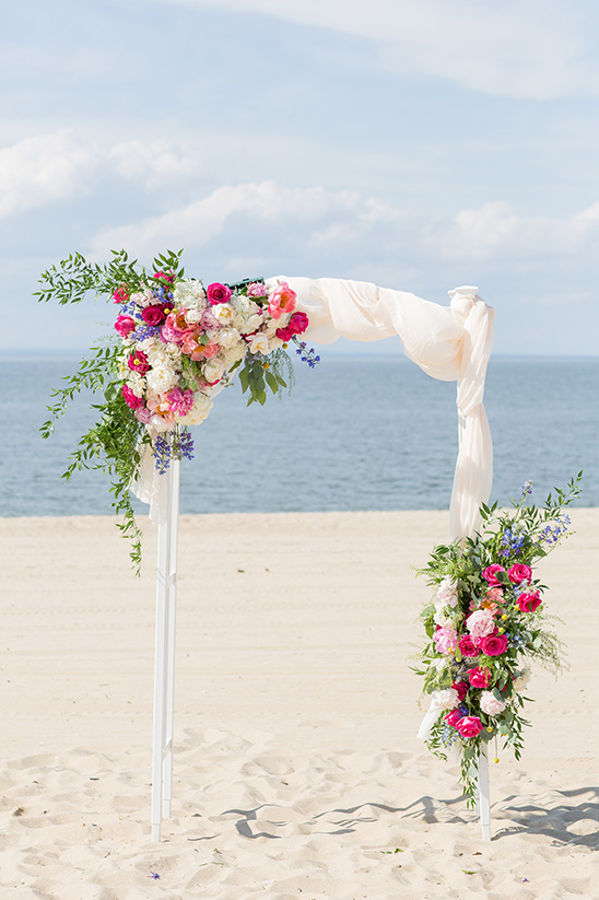 Beach wedding arch with colorful floral decorations
