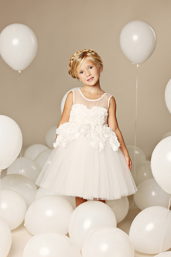Little girl in white dress surrounded by balloons