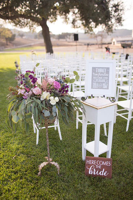 Wedding ceremony setup with floral arrangement and signs