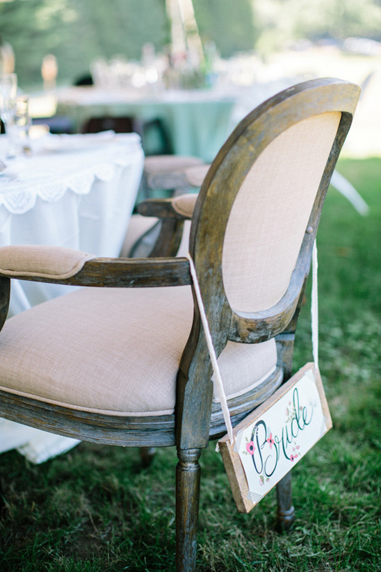 Bride chair signage decorates a rustic wedding reception