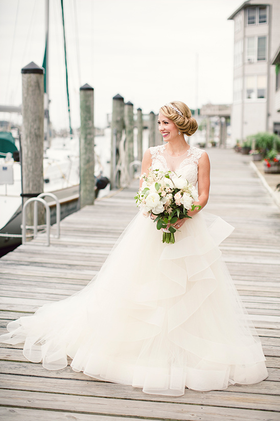 Elegant bride in lace wedding gown at waterfront venue