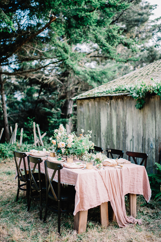 Outdoor dining table with rustic decor and floral arrangement