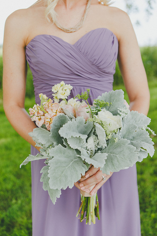 Bridesmaid in lavender dress holding wedding bouquet