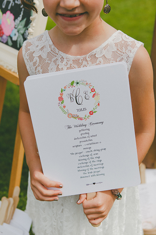 Girl holding wedding program fan with floral design
