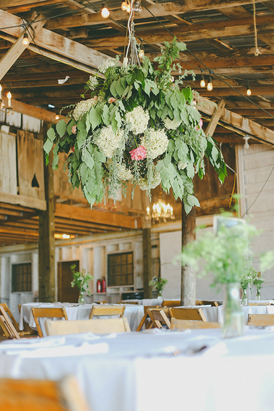 Hanging floral centerpiece in rustic wedding barn venue