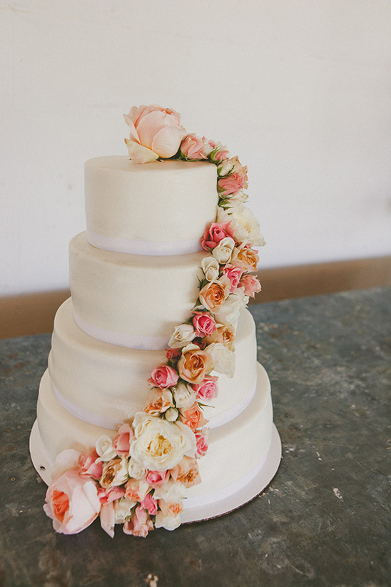 Four tier wedding cake with pink and white flowers